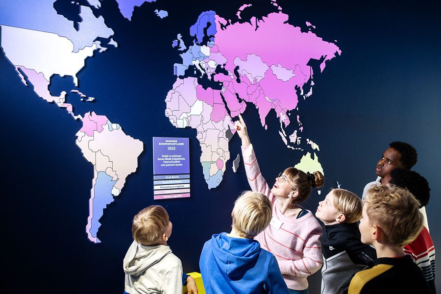 Museo-opas ja lapsiryhmä kuuntelemassa häntä.